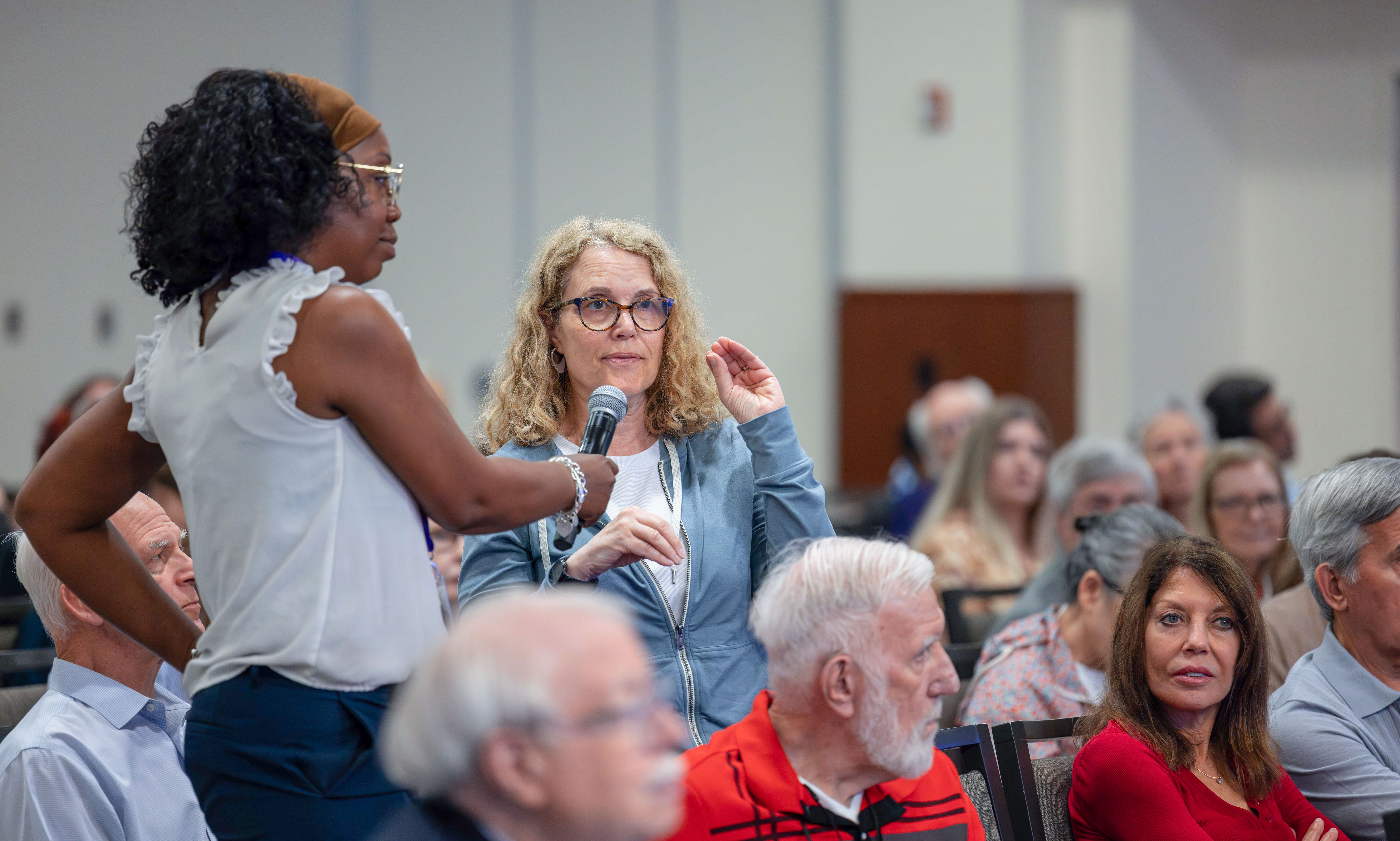 Members of the Quality of Life Symposium panel clap during the 2024 event.